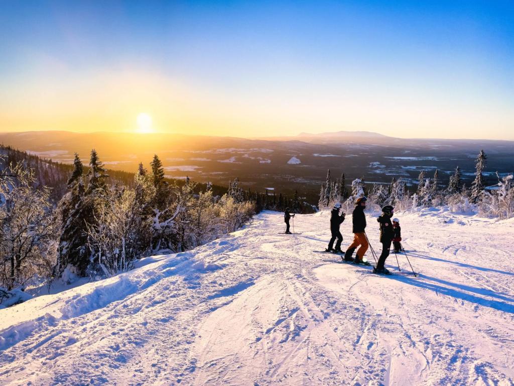 Skidåkare i solnedgång i backen ovanför Vemdalen